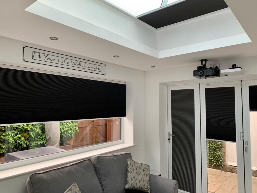 Black roof lantern blinds partially open beneath overhead glazing